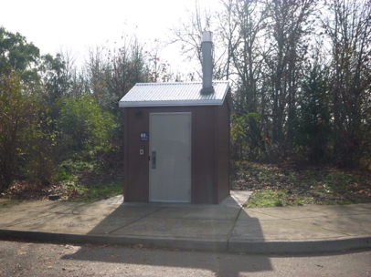 Accessible vault toilet in main parking lot – paved surface – sidewalk